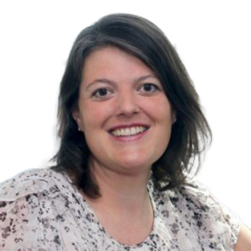 Smiling woman with shoulder-length dark hair wearing a light floral blouse, photographed against a plain light background.